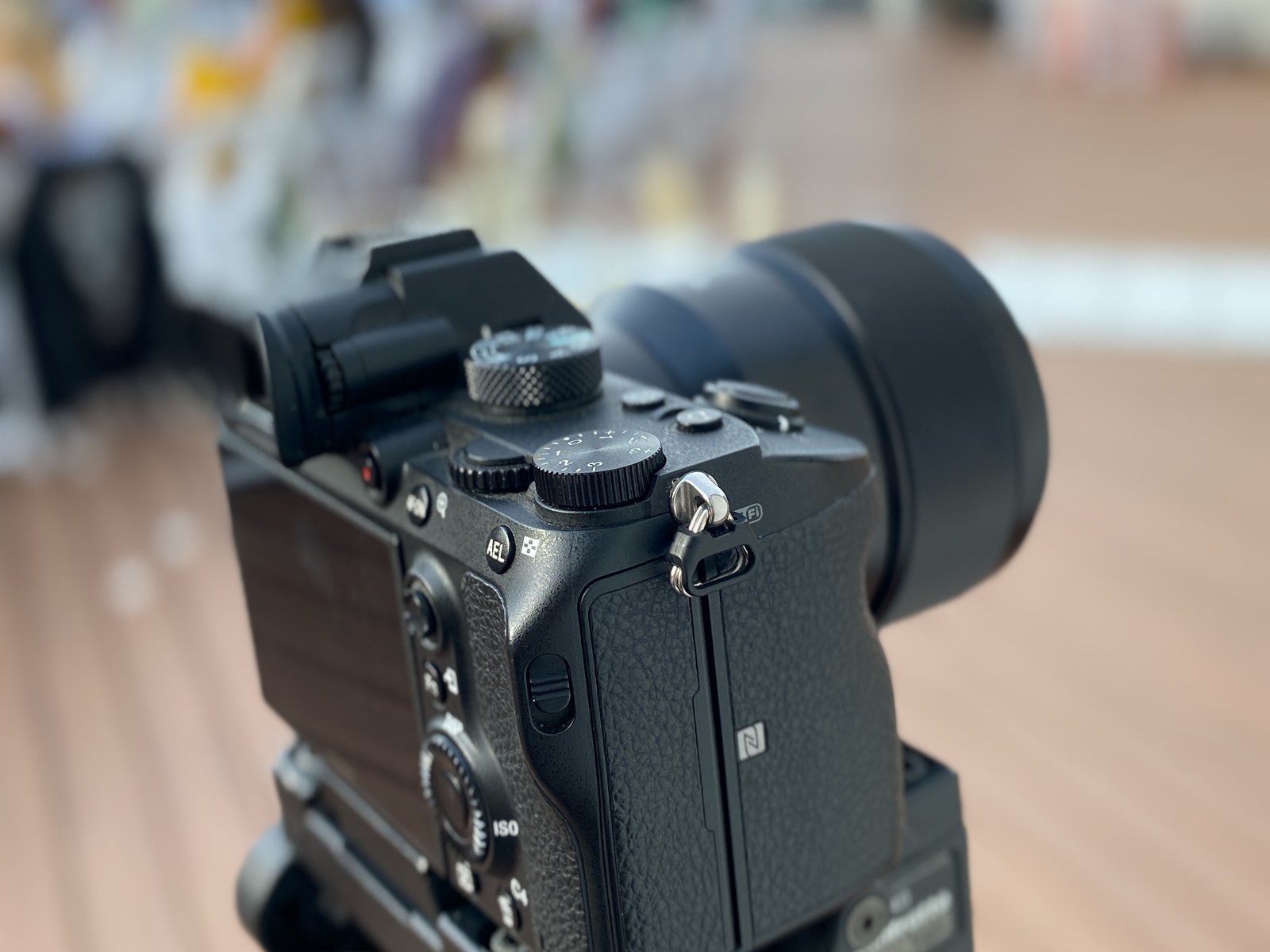 A mirrorless camera body and lens in close up with the room behind thrown out of focus