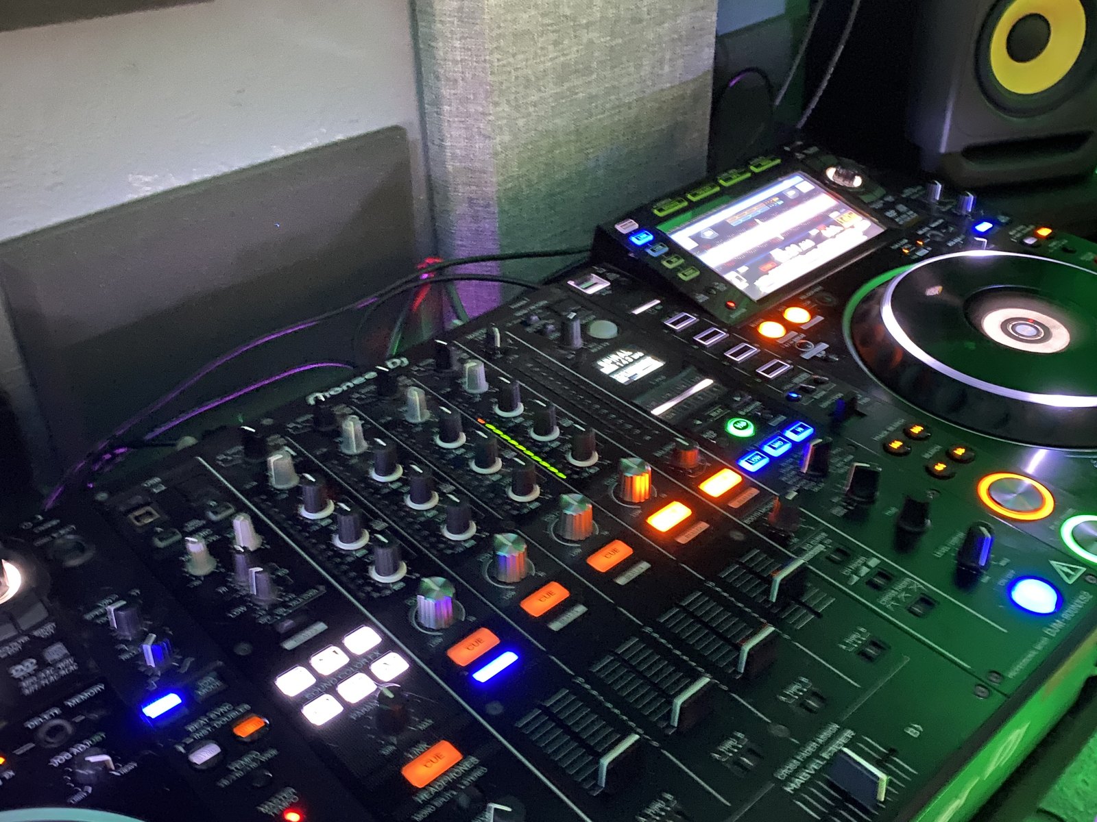 A close view of a DJ mixer and jog wheel with the channel lights on