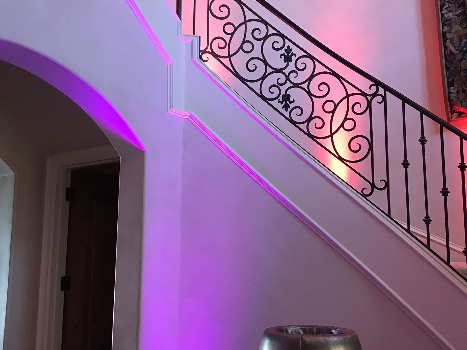 Two wash colors landing on the same stairwell wall, magenta below and warm red above the rail