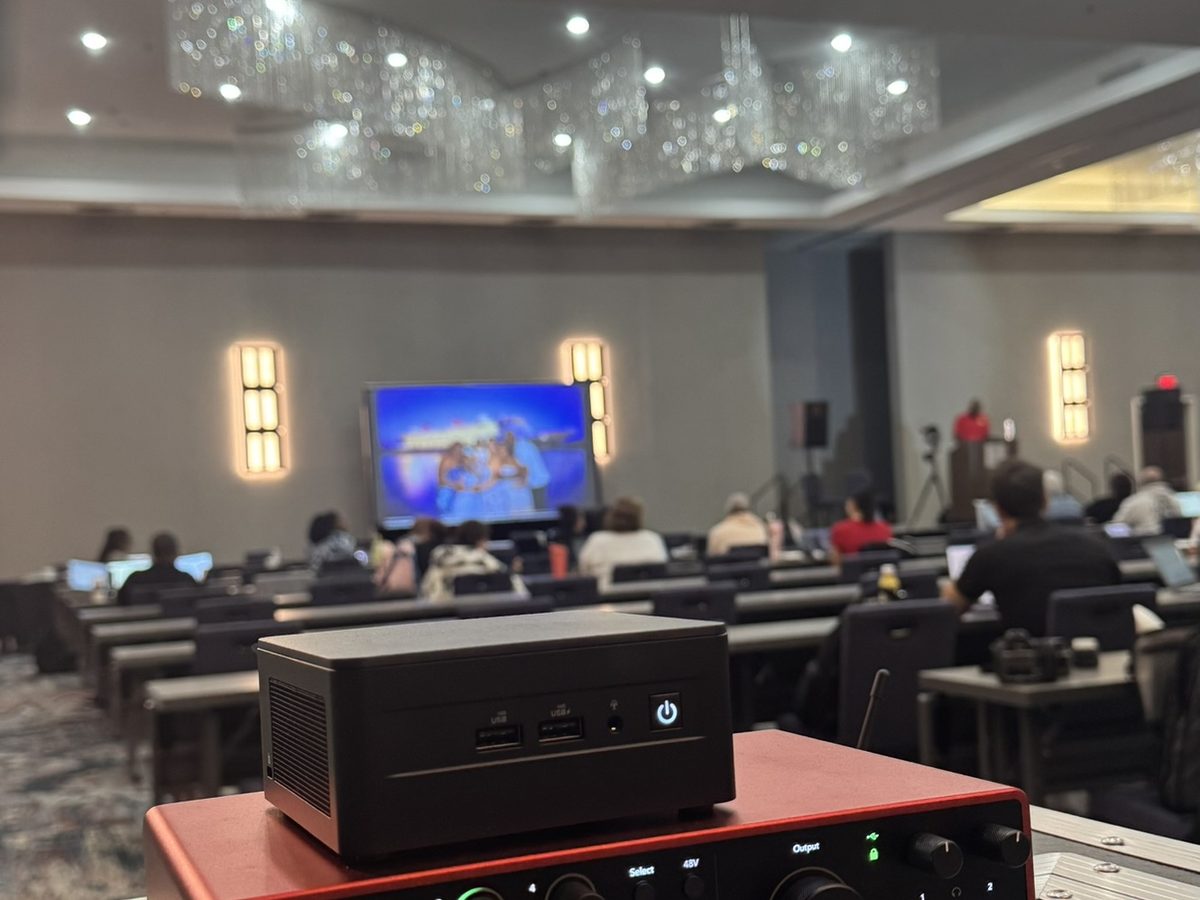 The De-Feedback processor on top of an audio interface at front of house, with a corporate session under way in a Dallas hotel ballroom